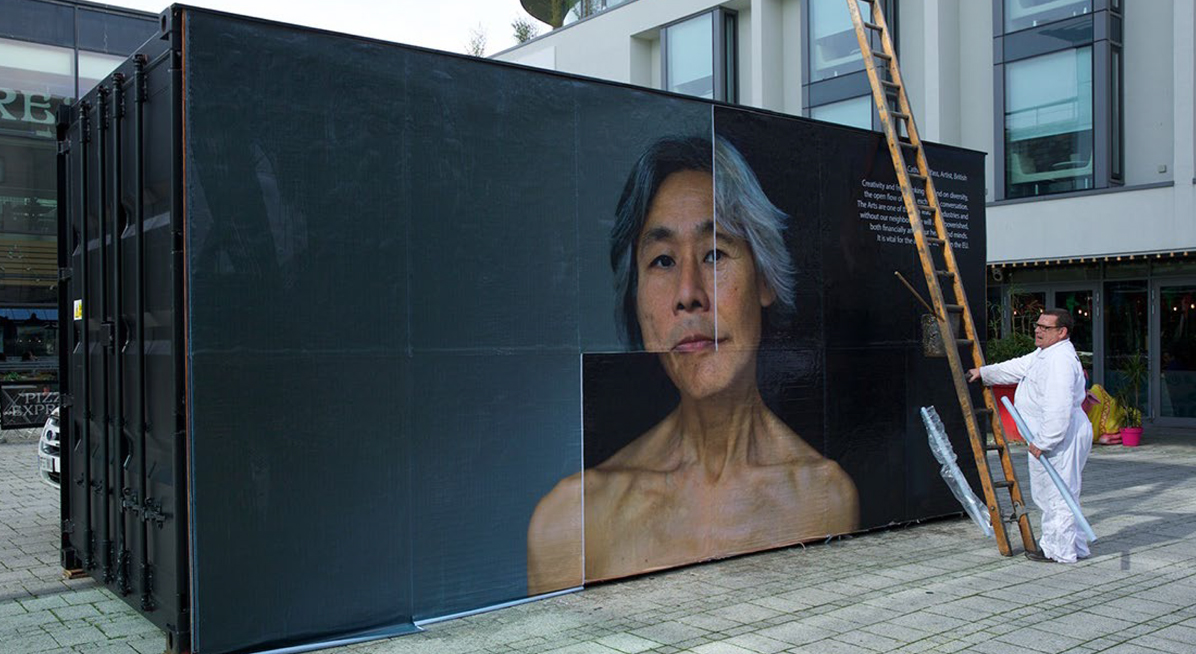Man pasting image onto billboard